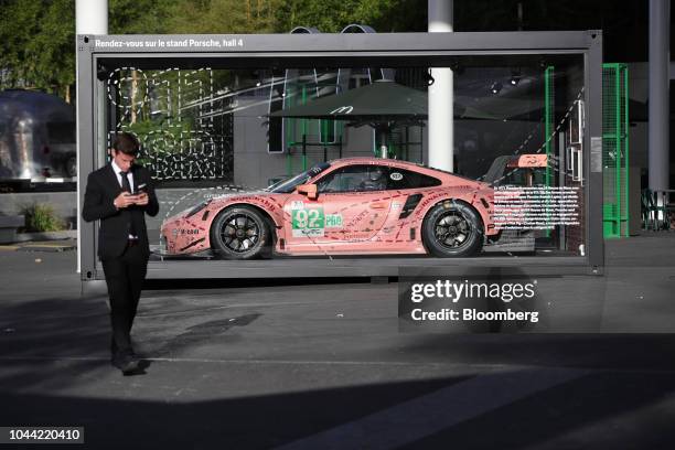 An attendee passes a Porsche 917 'Pink Pig' racing car during the Tomorrow in Motion event ahead of the Paris Motor Show in Paris, France, on Monday,...
