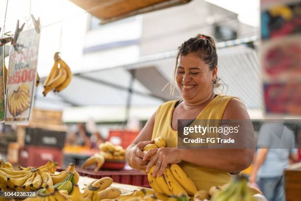 portrait of confident owner - selling bananas at farmers market - feirante imagens e fotografias de stock