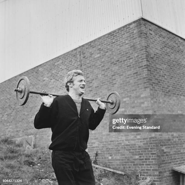 Scottish soccer player Denis Law of Manchester United FC training outdoors with a barbell, UK, 1st August 1968.