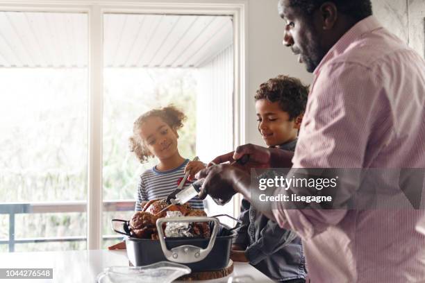 fathers preparing thanksgiving turkey - fathers day dinner stock pictures, royalty-free photos & images