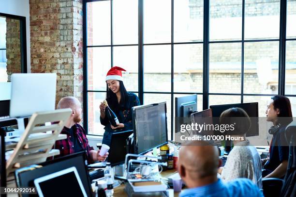 asian woman in santa hat holding champagne in modern office - christmas office party stock pictures, royalty-free photos & images