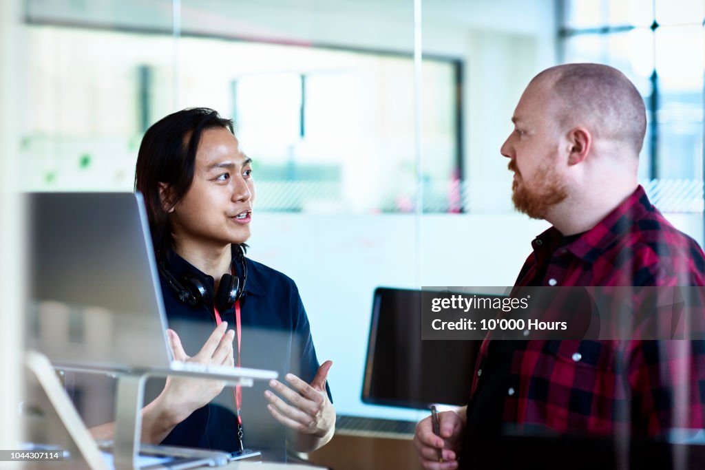 Young Asian IT consultant advising manager in office