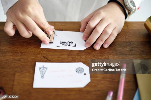 girl's hands stamping a homemade christmas gift tag - home made gift stock pictures, royalty-free photos & images