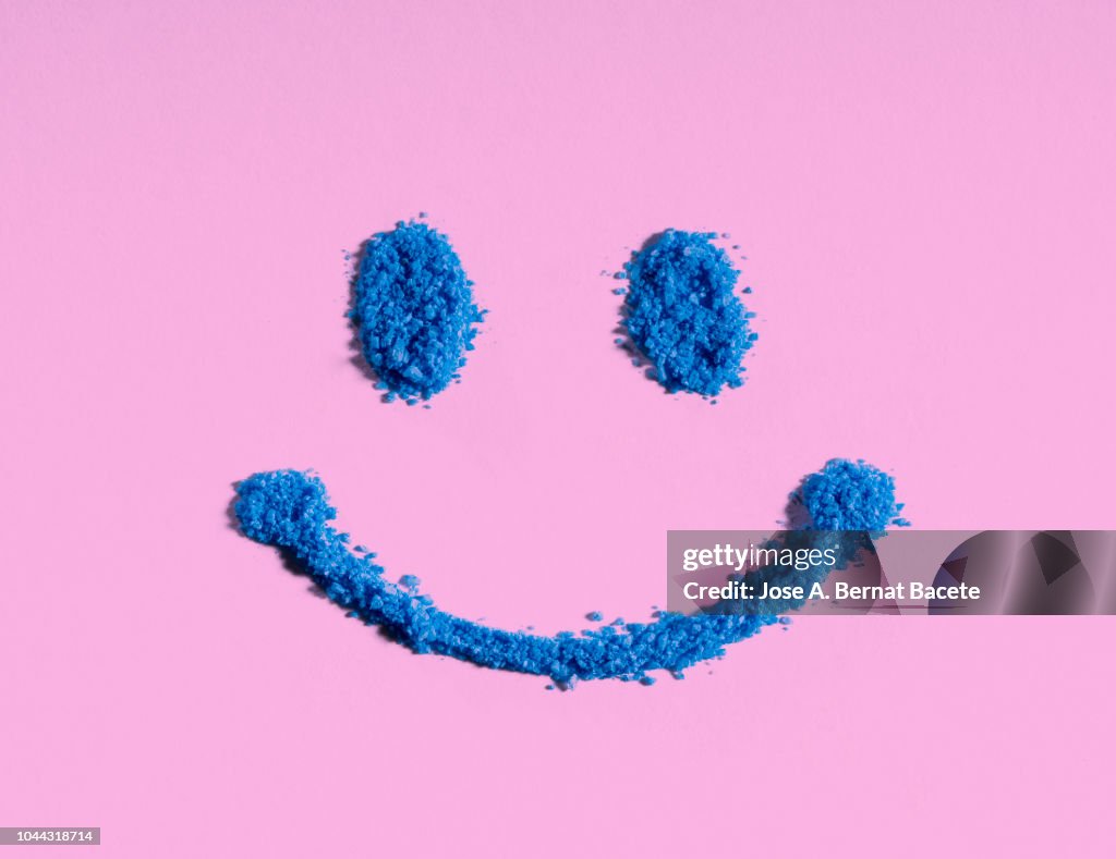 Drawing of a face and smiling eyes on a pink background.