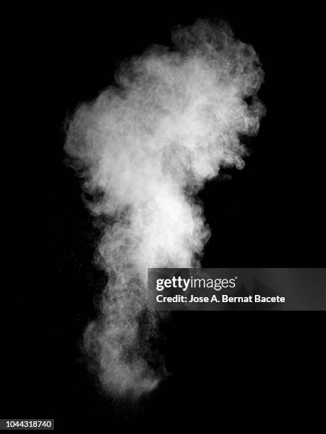 explosion by an impact of a cloud of particles of powder of color white on a black background. - chimney stock-fotos und bilder