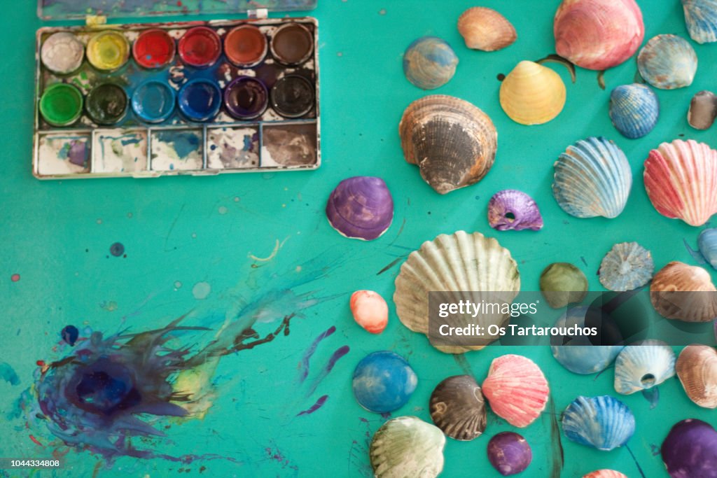 Watercolor painted sea shells over a green stained background