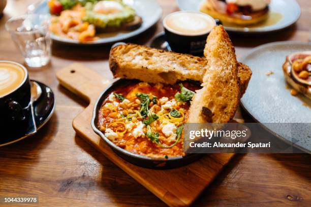 close up of shakshuka served in cooking pan on the table in cafe - meal food dish stock-fotos und bilder