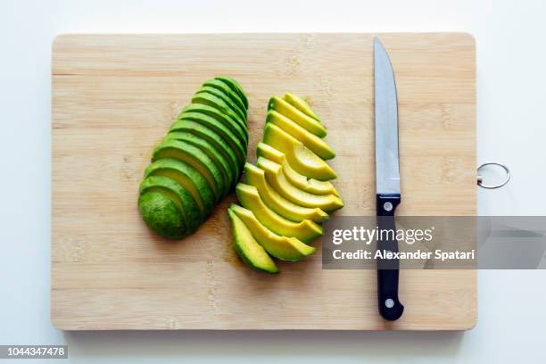 freshly cut sliced avocado on a cutting board - cutting avocado stockfoto's en -beelden
