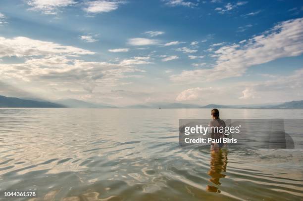 woman relaxing in the water, lake ohrid, the most peaceful destination in the balkans - lake ohrid stockfoto's en -beelden