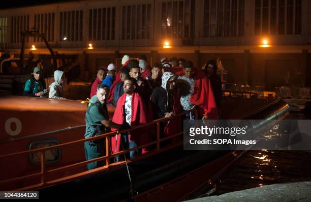 Moroccan and algerian migrants stand on a rescue boat after their arrival at the Port of Malaga. Spains Maritime Rescue service rescued 96 migrants...