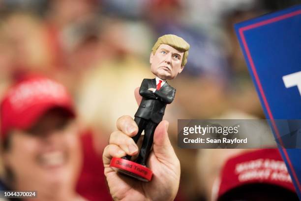 Man holds up a President Donald Trump bobblehead before a campaign rally at Freedom Hall on October 1, 2018 in Johnson City, Tennessee. President...