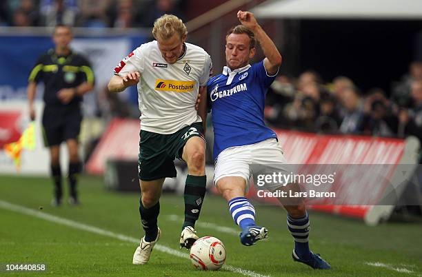 Tobias Levels of Moenchengladbach challenges Ivan Rakitic of Schalke during the Bundesliga match between FC Schalke 04 and Borussia Moenchengladbach...