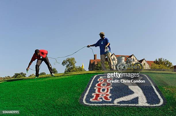 Painter Charles English touches up a logo near the clubhouse before the second round of THE TOUR Championship presented by Coca-Cola, the final event...