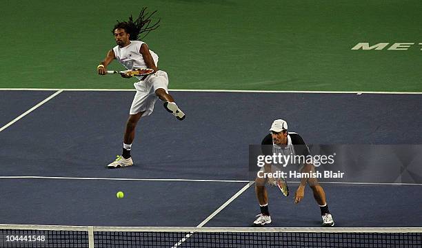 Dustin Brown of Jamaica plays an overhead shot with team mate Rogier Wassen of Netherlands looking on during their doubles semi final match against...