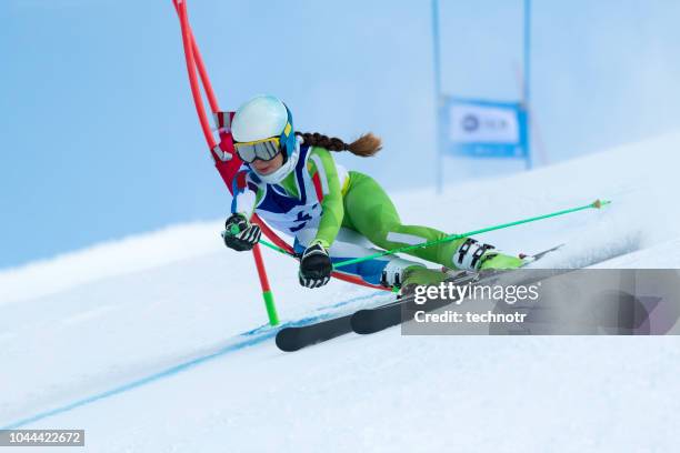 jonge vrouwen reuzenslalom tegen de blauwe hemel - alpineskiën stockfoto's en -beelden