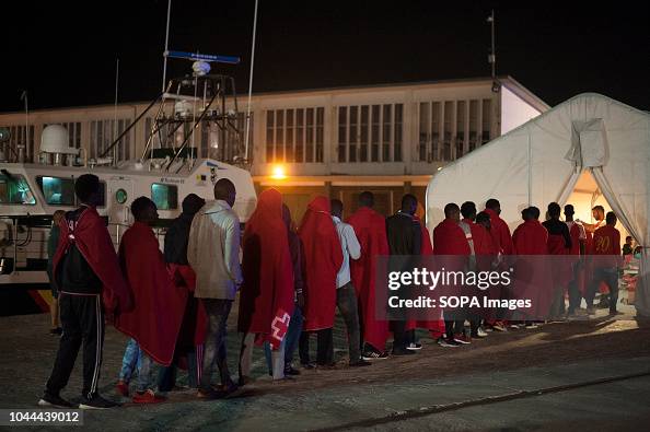 Spanish Queue Migrants in a queue walk toward a tent of Spanish Red Cross after ...