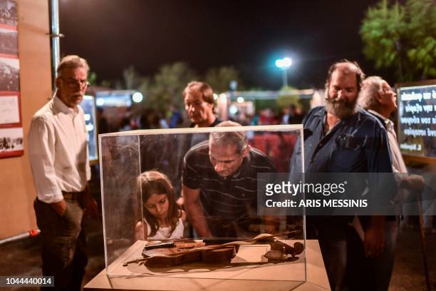 People visit an exibition for the 100 years anniversary of the Greek Communist party during an annual festival of the party's youth wing in Athens on...