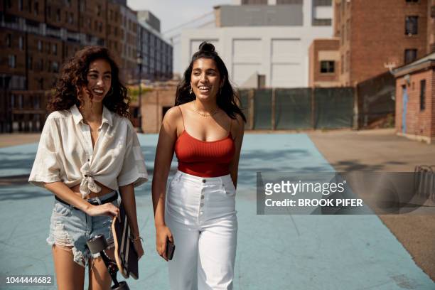 young females hanging out in city - rode korte broek stockfoto's en -beelden