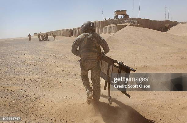 Army MEDEVAC helicopter crew chief SPC David Doll from Dallas, TX with Dustoff Task Force Shadow of the 101st Combat Aviation Brigade carries a...