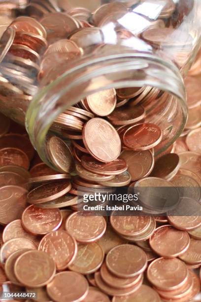 close-up view of euro cent coins in glass jar on table - coin photos stock-fotos und bilder