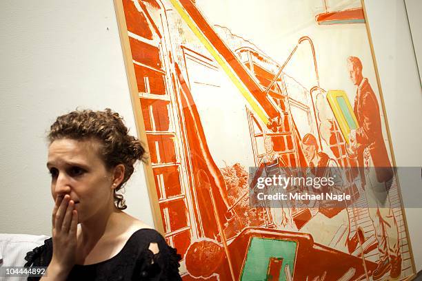 Woman stands in front of Neo Rauch's "Einbruch" as it, and other art from Lehman Brothers' collection, is auctioned off at Sotheby's on September 25,...