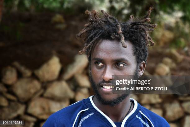 Migrant recently arrived from Eritrea through Libya, looks on as he walks out of the migrants reception and identification center, or "Hot Spot" in...