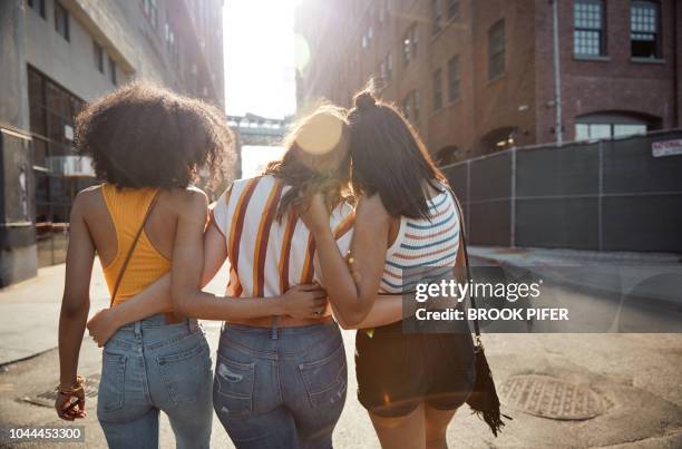 young females hanging out in city - girl in black jeans stockfoto's en -beelden