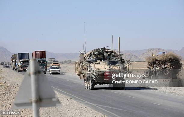 By Dan De Luce, Afghanistan-unrest-US-prosecute-military Local vehicles keep their distance as a Stryker armored vehicle from the US Army's 5th...
