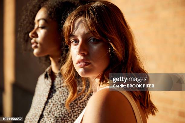 portrait of young woman in city - stylish man looking away stock-fotos und bilder