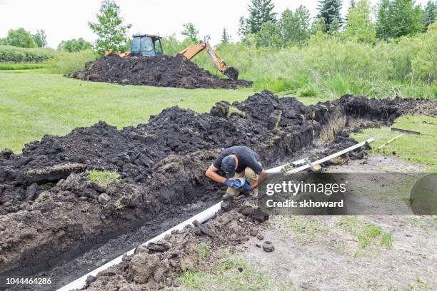 de installatie van het septische systeem van de heuvel - graven stockfoto's en -beelden