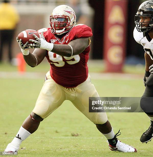 Florida State defensive tackle Jacobbi McDaniel pulls in an interception in front of Wake Forest offensive guard Joe Looney, right, at Doak Campbell...