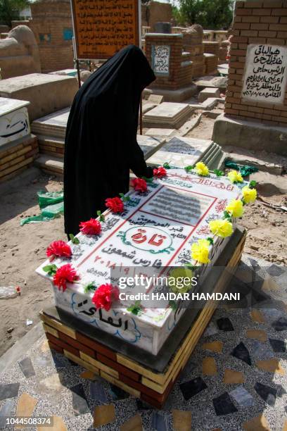 An Iraqi woman is seen around the grave of slain model and Instagram starlet Tara Fares in the central holy shrine city of Najaf on October 2, 2018....