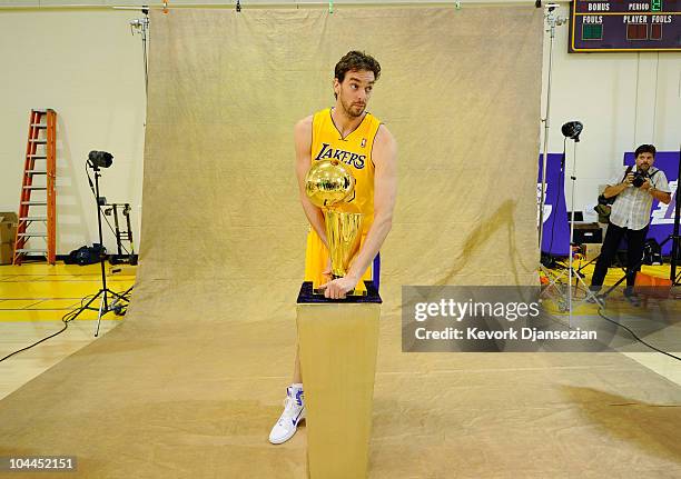 Pau Gasol of the Los Angeles Lakers poses for a photograph with the NBA Finals Larry O'Brien Championship Trophy during Media Day at the Toyota...