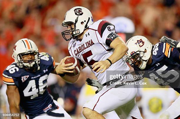 Quarterback Stephen Garcia of the South Carolina Gamecocks rushes upfield against Craig Stevens and Antoine Carter of the Auburn Tigers at...