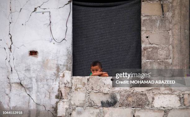 Syrian child gazes while standing outside his house in an opposition-held neighbourhood of the southern Syrian city of Daraa on October 1, 2018.