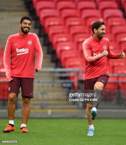 Barcelona's Uruguayan forward Luis Suarez and Barcelona's Argentine forward Lionel Messi attends a team training session at Wembley Stadium in north...