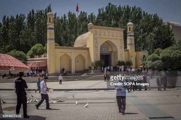 Uighur Chinese local Muslims leave Id Kah Mosque after Friday afternoon prayers under Police surveillance in the Kashgar old Town, northwestern...