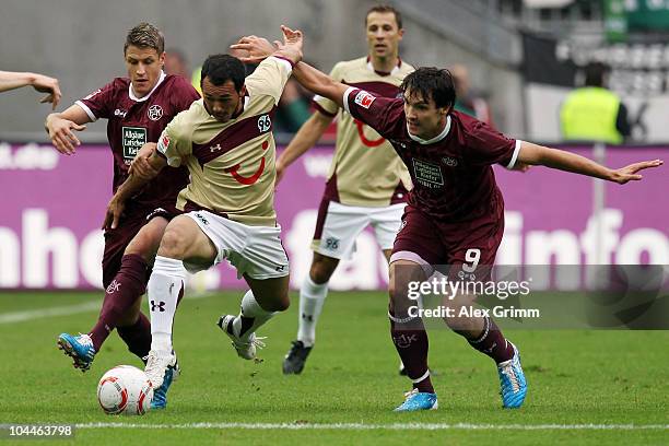 Sergio Pinto of Hannover is challenged by Ivo Ilicevic and Srdjan Lakic of Kaiserslautern during the Bundesliga match between 1. FC Kaiserslautern...