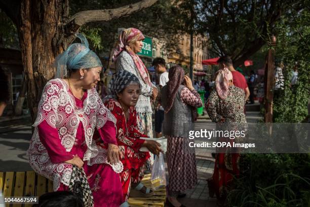 Uyghur women wearing traditional clothes seen watching the Uyghur dancing show in the streets of Kashgar, northwestern Xinjiang Uyghur Autonomous...