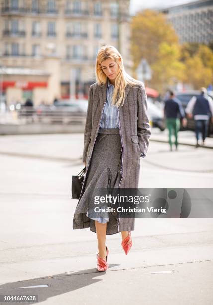 Ada Kokosar wearing a skirt worn over a stripped button shirt dress, grey coat is seen outside Giambattista Valli during Paris Fashion Week...