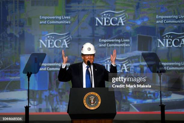 President Donald Trump reacts after putting on a hard hat as he addresses the National Electrical Contractors Convention on October 2, 2018 in...