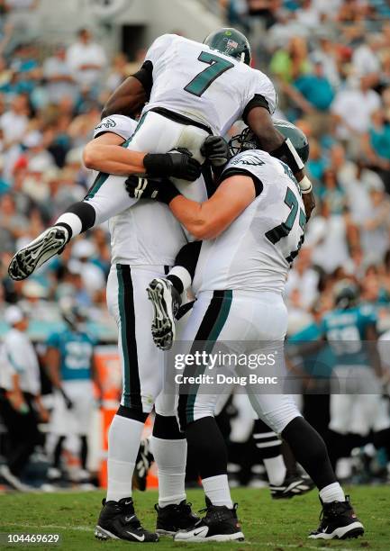 Quarterback Michael Vick of the Philadelphia Eagles celebrates with offensive linemen Todd Herremans and Mike McGlynn after throwing a touchdown pass...