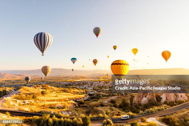 heißluftballons über cappadocia bei sonnenaufgang, türkei - cappadocia hot air balloon stock-fotos und bilder