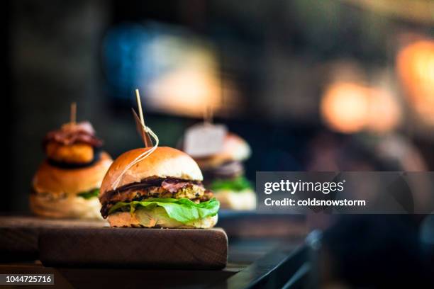 verse vlam gegrilde hamburgers weergegeven in een rij op de voedselmarkt - burgers stockfoto's en -beelden