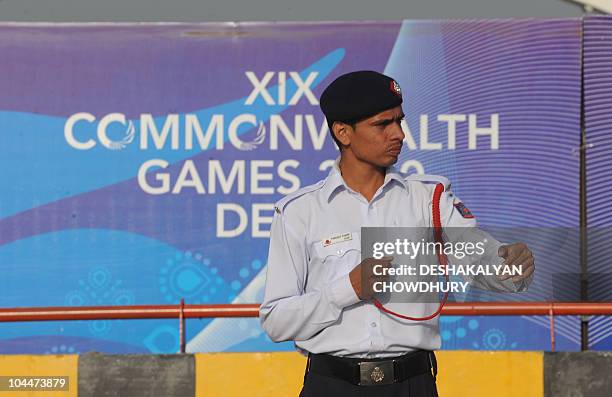 An Indian traffic policeman gestures on a dedicated lane exclusively catering to athletes and delegations of the Commonwealth Games near the...