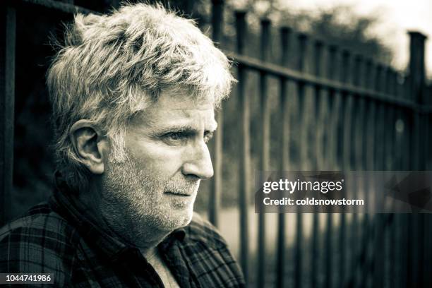 homeless lonely senior male standing outdoors - beggar stock pictures, royalty-free photos & images