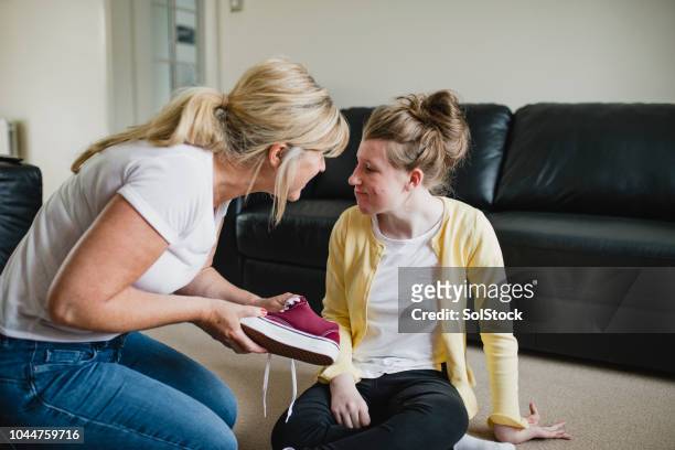 madre a hija con discapacidad vestirse en casa - microcephaly fotografías e imágenes de stock