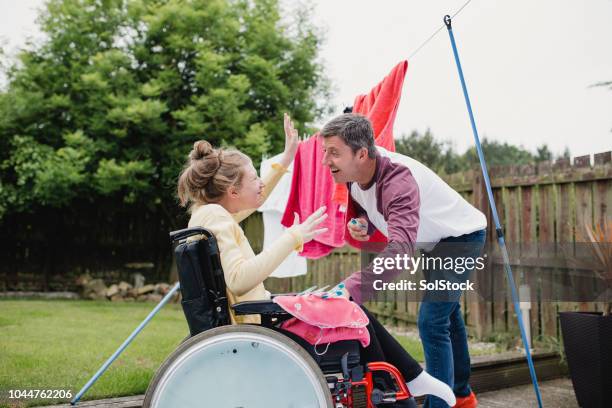 papa de multitâche avec fille handicapée heureuse - sclérose latérale amyotrophique photos et images de collection