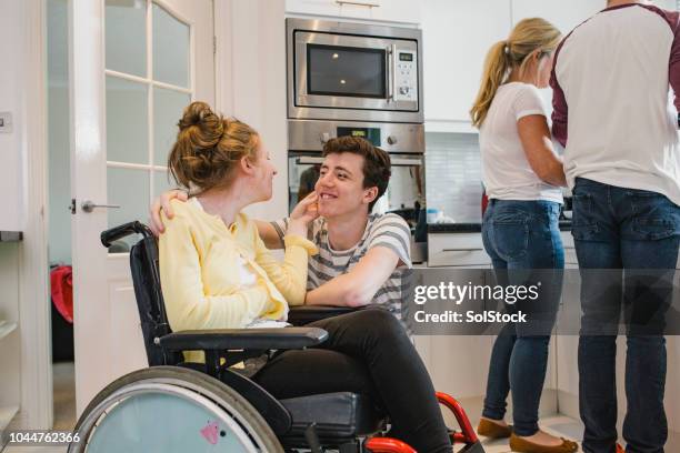 teenager playing with disabled sister at home - amyotrophic lateral sclerosis stock pictures, royalty-free photos & images