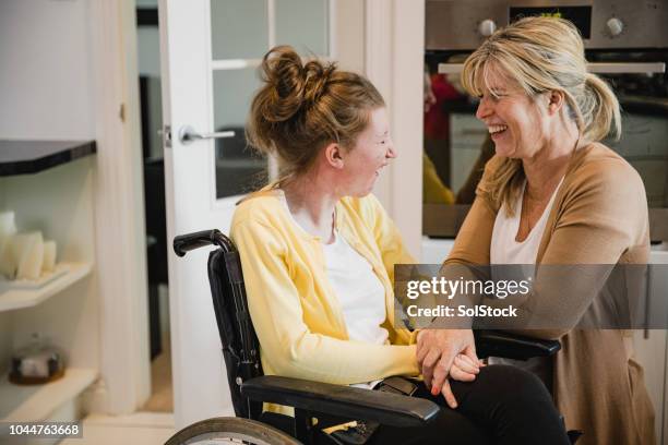 mama und behinderte tochter in der küche - physical disability stock-fotos und bilder